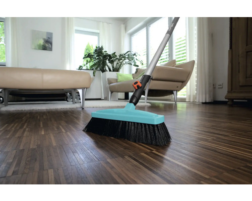 Kehrbesen mit Stiel auf Holzboden in einem Wohnzimmer