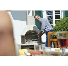 Mann grillt mit einem Gartengrill Lebensmittel im Freien
