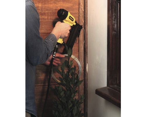 Handwerker befestigt Holzleiste mit einem Druckluftnagler von Stanley