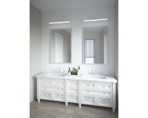 Badezimmer mit Doppelwaschtisch, Spiegeln und Beleuchtung.