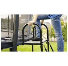 Person steigt über eine Leiter auf ein Gartentrampolin