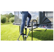 Person steigt auf eine Trampolinleiter mit Haltegriff