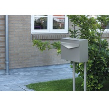 Briefkasten aus Metall auf zwei Pfosten im Vorgarten