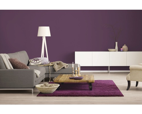 Wohnzimmer mit grauer Couch, Holztisch, weißem Sideboard und lila Wandfarbe