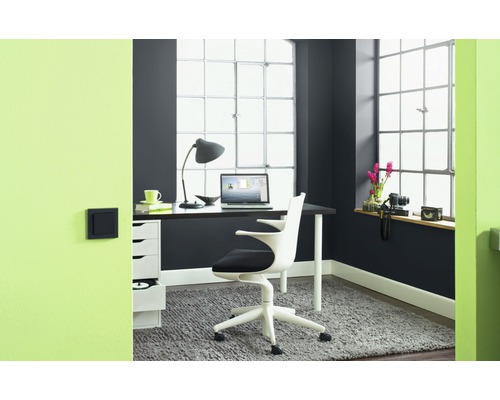 Büro mit Schreibtisch, Bürostuhl, Lampe und Dekoration in einem hellen Raum