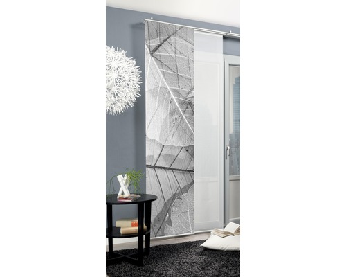 Dekorative Schiebegardine mit Blattmotiv neben einem Tisch und einer Lampe