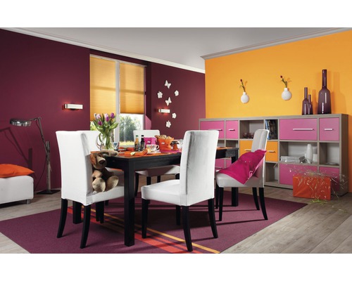 Esszimmer mit Tisch, Stühlen und Sideboard in einem farbenfrohen Interieur