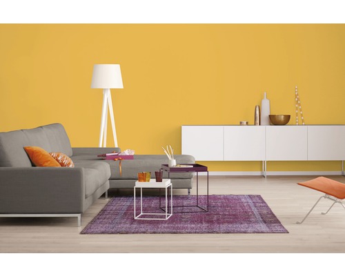 Wohnzimmer mit grauem Sofa, weißer Stehlampe, lila Teppich und gelber Wand