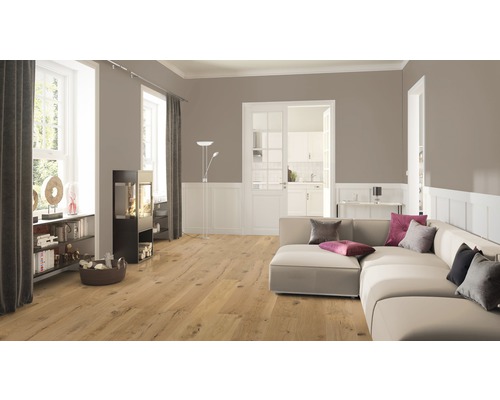 Wohnzimmer mit Holzboden, Sofa und Kaminofen