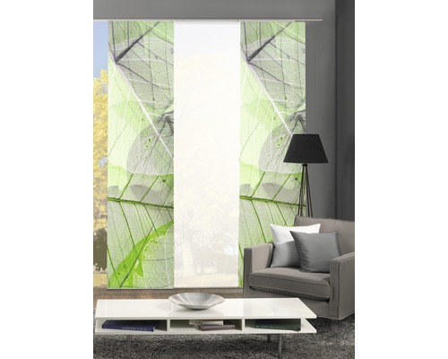 Wohnzimmer mit Schiebegardinen mit Blattmuster, Couch und Tisch