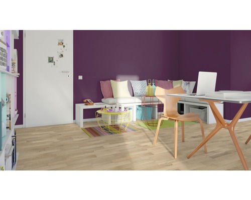 Einrichtung eines Zimmers mit Schreibtisch, Stuhl und Sitzgelegenheit vor einer lila Wand