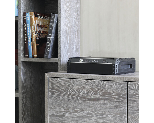 Schwarzer Tresor auf einem Holzschrank mit Büchern