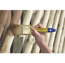 Eine Person streicht mit einem Pinsel eine Holzwand. Bondex Logo ist sichtbar.