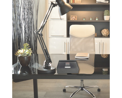 Schreibtischszene mit einem Möbeltresor, einer Schreibtischlampe und einem Bürostuhl