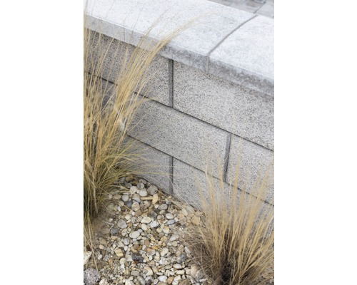 Gartenmauer aus Betonsteinen mit Ziergras und Kies