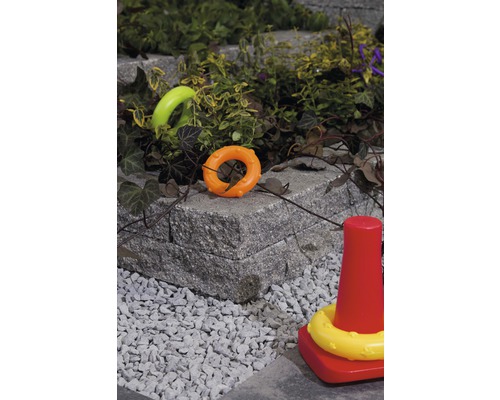 Spielzeug auf Pflastersteinen und Kies im Garten