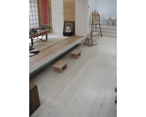 Helles Zimmer mit Holzboden, Treppenstufen, Holzhocker und Dekorationen
