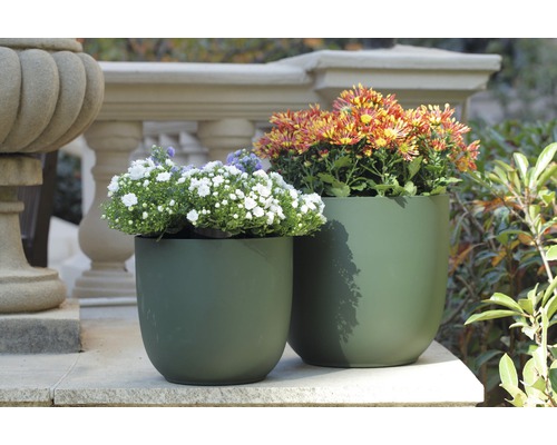 Zwei grüne Pflanzgefäße mit Blumen