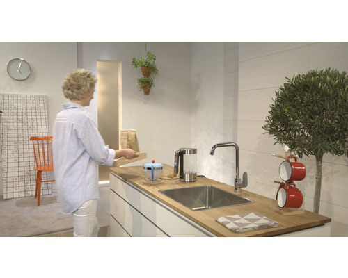 Moderne Küche mit Spüle, Armatur und Küchenutensilien auf einer Holzplatte