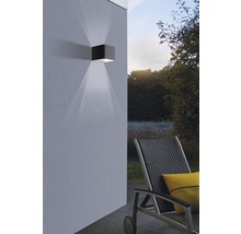 Kubische Außenwandleuchte aus Metall mit Lichtkegel an Hauswand
