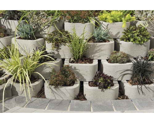 Pflanzen in einer gestuften Mauer aus Betonsteinen