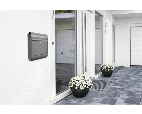 Grauer Briefkasten an einer Hauswand in Hauseingangsnähe