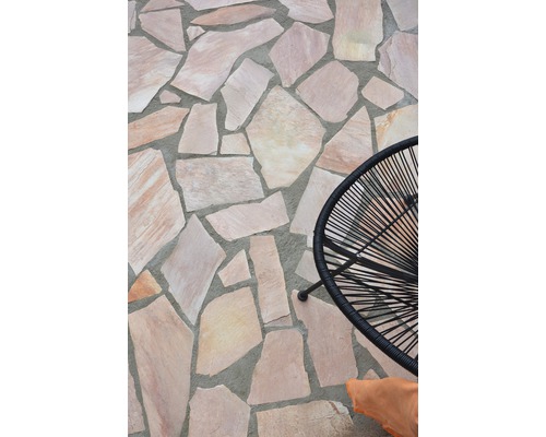 Verlegung von Polygonalplatten auf einer Terrasse mit einem Stuhl