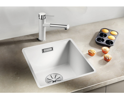 Küchenspüle mit Armatur und Muffins auf einer Arbeitsfläche