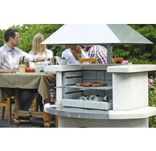 Gemauerter Gartengrill mit Grillgut und Personen im Hintergrund