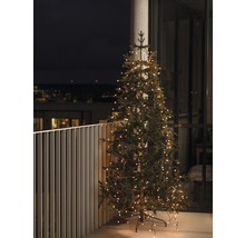 Künstlicher Weihnachtsbaum mit Beleuchtung auf einem Balkon.