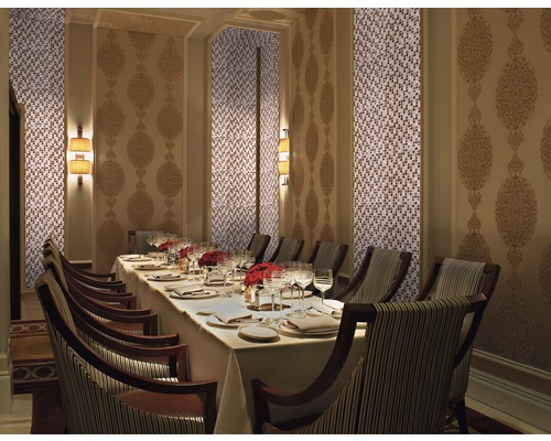 Elegantes Esszimmer mit Mosaikwand, dekoriertem Wandpaneel, gedecktem Tisch und Stühlen