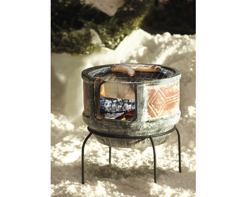 Grillofen mit Würstchen auf einem Rost im Schnee.