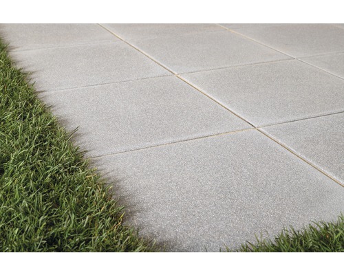 Graue Terrassenplatten mit Rasen im Garten