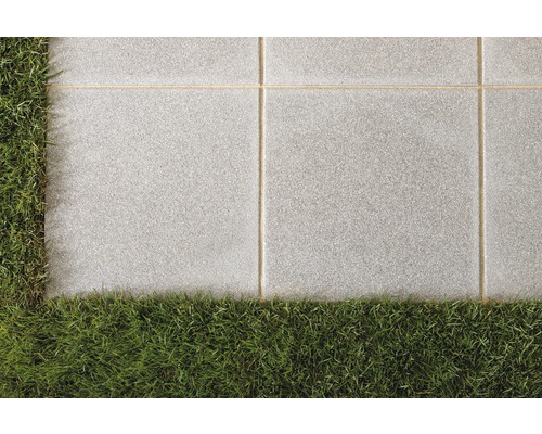 Graue Terrassenplatten mit Gras im Garten
