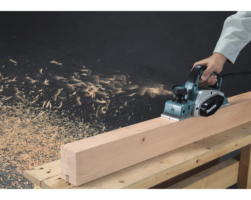 Makita Elektrohobel beim Bearbeiten eines Holzstücks auf einer Werkbank