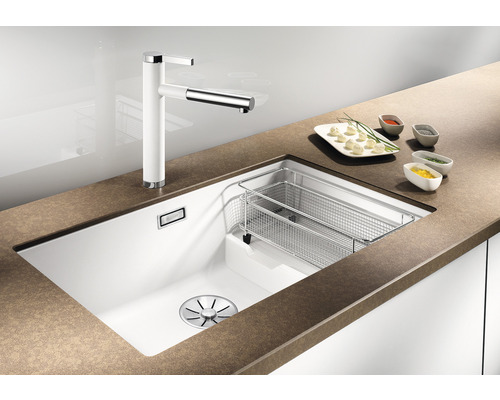 Küchenspüle mit Abtropfkorb und Wasserhahn auf einer Küchentheke