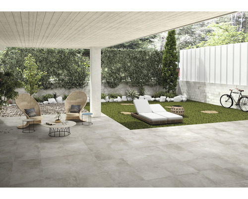 Terrasse mit Bodenfliesen, Gartenmöbeln und Rasenfläche