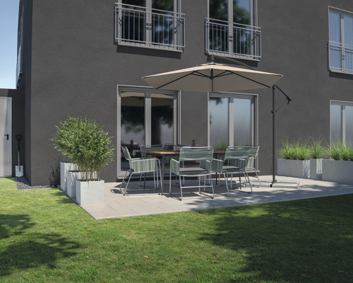 Terrasse mit Esstisch, Stühlen, Sonnenschirm und Pflanzkästen vor einem Wohnhaus.