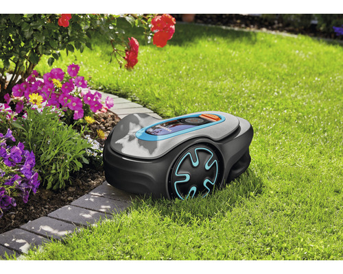 Mähroboter auf einer Rasenfläche neben einem Blumenbeet