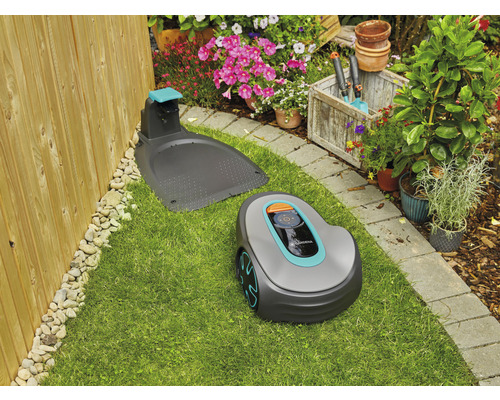 Gardena Mähroboter mit Ladestation auf Rasenfläche in einem Garten