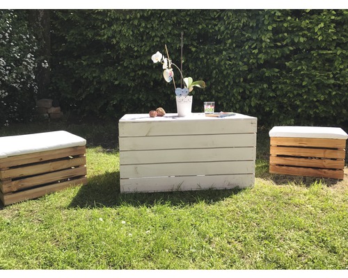 Gartenmöbel-Set aus Holzkisten mit Tisch und Hockern auf einer Rasenfläche