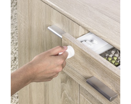 Eine Person öffnet eine Schublade mit Medikamenten mit einem Kindersicherungsschloss.