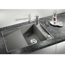 Spüle aus Granit mit Abtropffläche und Armatur auf einer Arbeitsplatte.