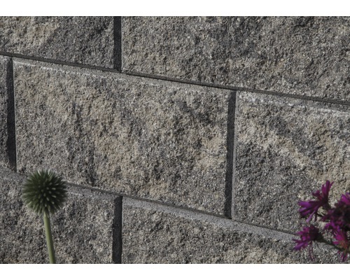 Graue Pflastersteine bilden eine Mauer.