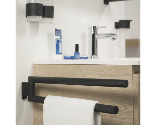 Badezimmer mit Waschbecken, Armatur, Zahnputzbecher, Handtuch und schwenkbarem Handtuchhalter