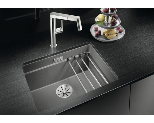 Küchenspüle aus Verbundwerkstoff mit Abtropfgestell und Armatur auf dunkler Arbeitsplatte