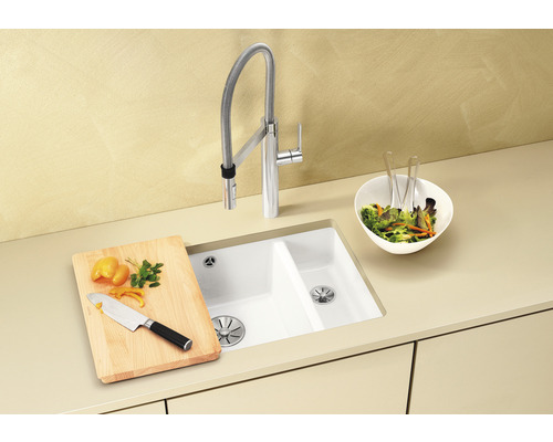 Küchenspüle mit Armatur, Schneidebrett, Messer und Salatschüssel