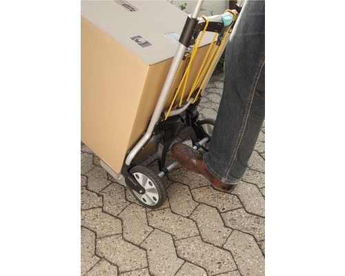 Eine Person benutzt eine Sackkarre zum Transport eines Kartons.