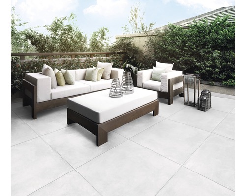 Terrasse mit Sitzgruppe und Bodenfliesen im Außenbereich.