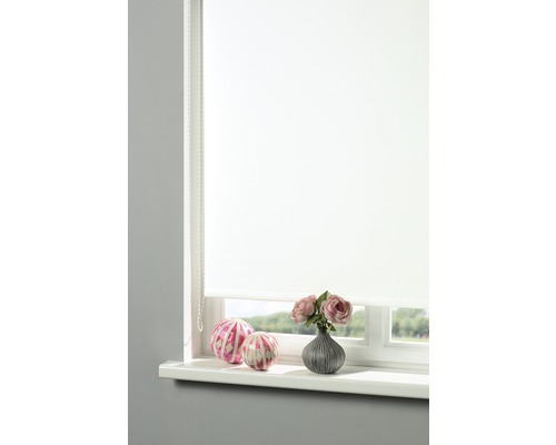 Weißes Rollo am Fenster mit Dekoration